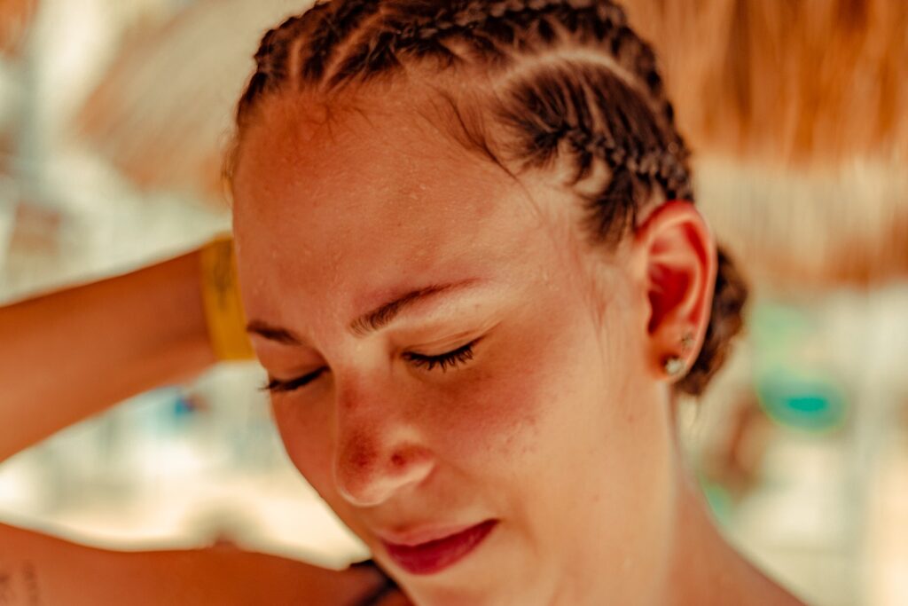 Close Up Photo of a Woman with Braids sweating in extreme heat