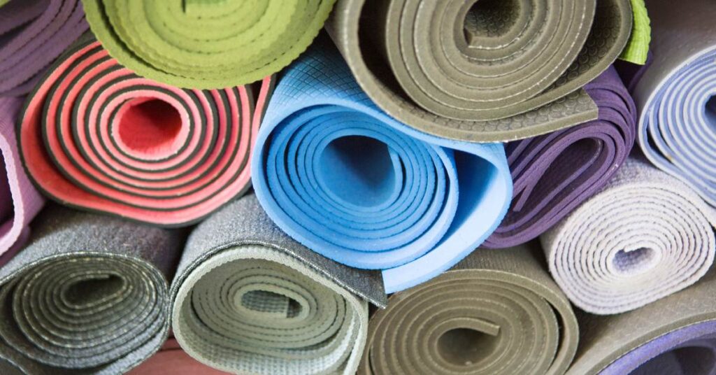 yoga mats for sweaty hands. bunch of mats rolled up in different colors
